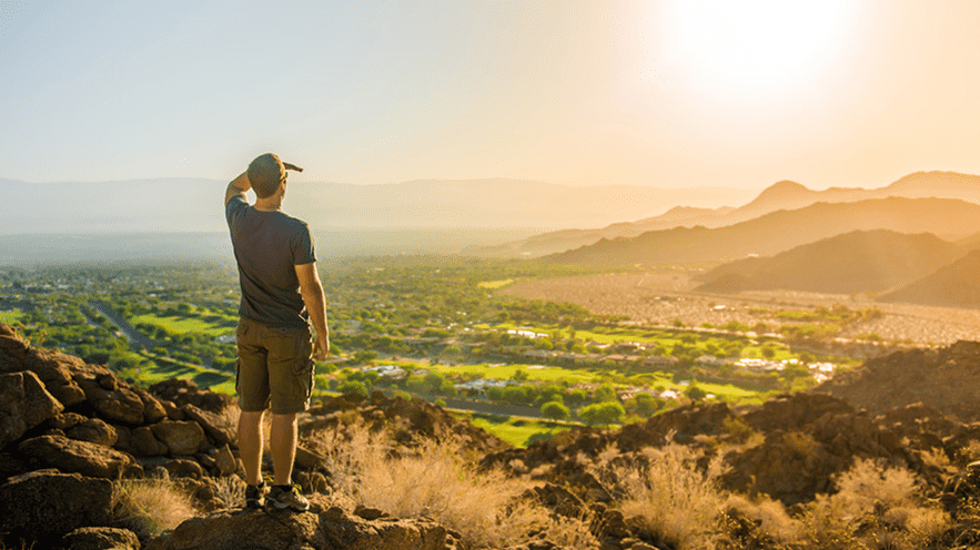 Person overlooking desert landscape at sunset near La Quinta Resort.
