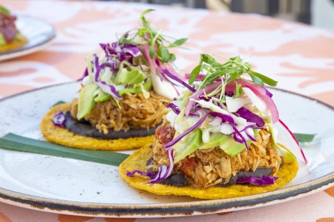 Tacos de pollo desmenuzado con ensalada y verduras frescas.