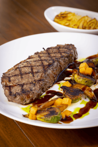 Delicious grilled steak served with roasted vegetables and balsamic glaze at La Quinta Resort & Club.