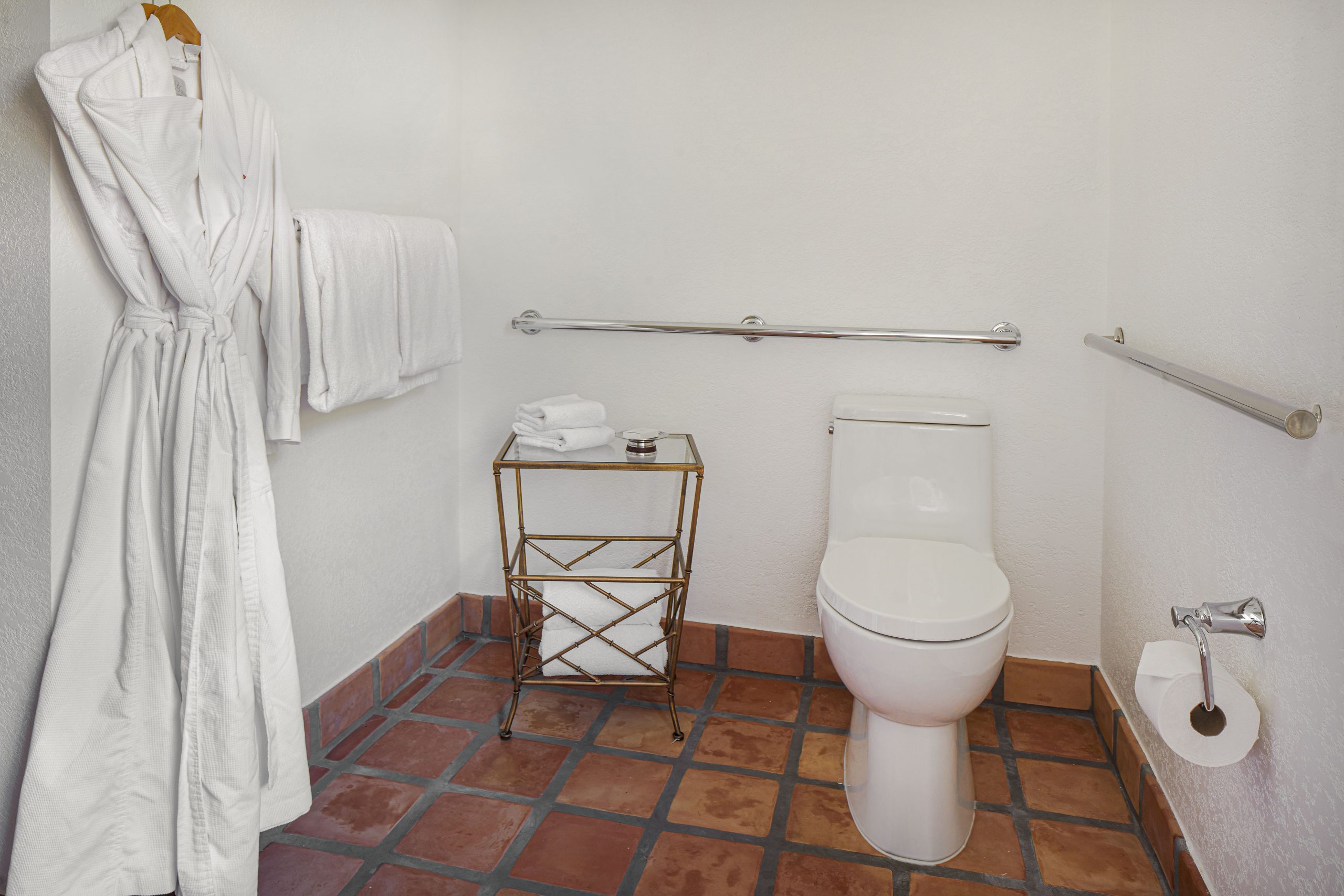 Accessible bathroom with roll-in shower, hearing notification devices, and grab bars for mobility su.