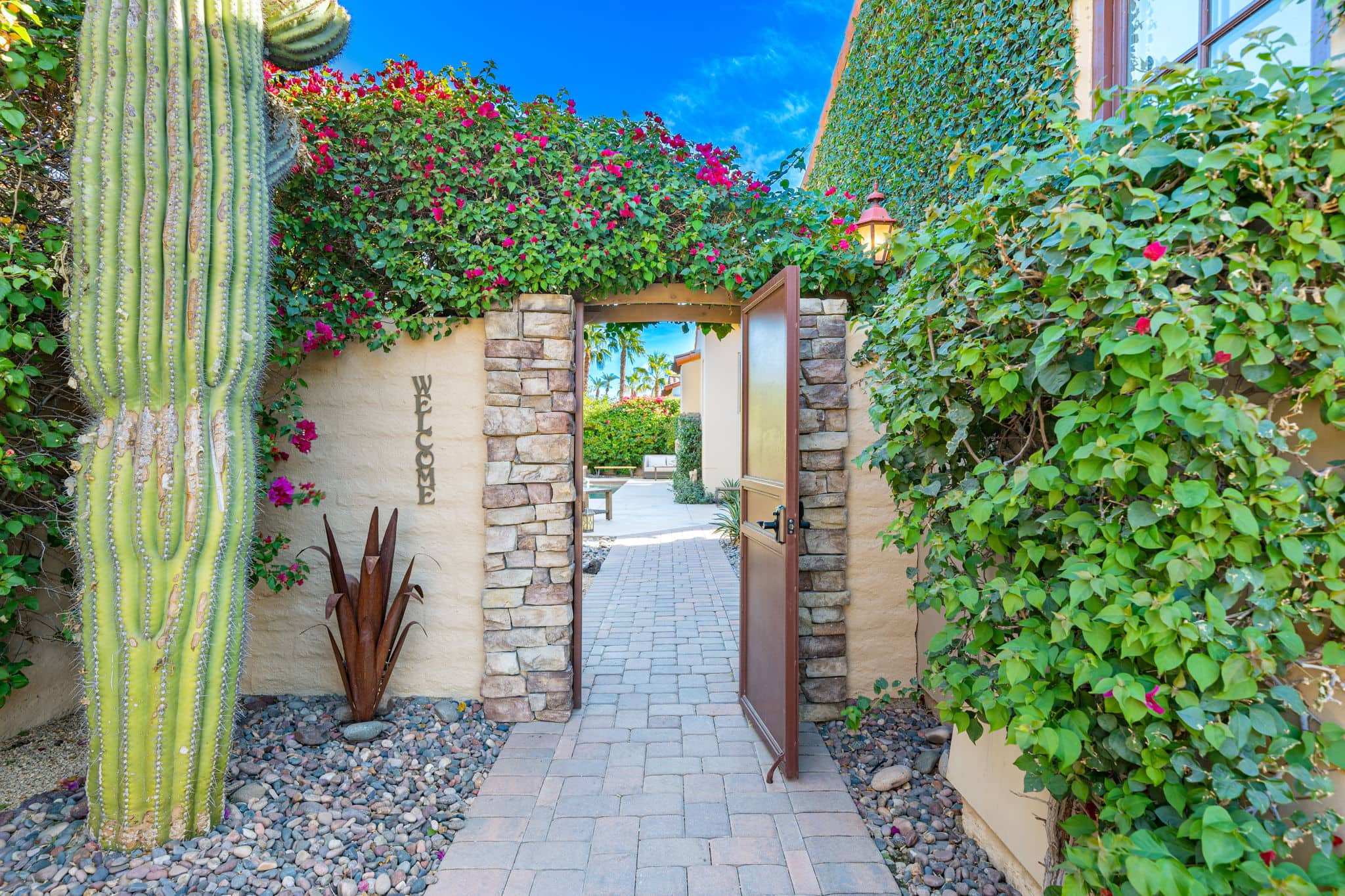 Entrance to La Quinta Resort & Club with lush greenery and vibrant flowers.