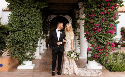 Elegant wedding couple at La Quinta Resort & Club under floral archway.