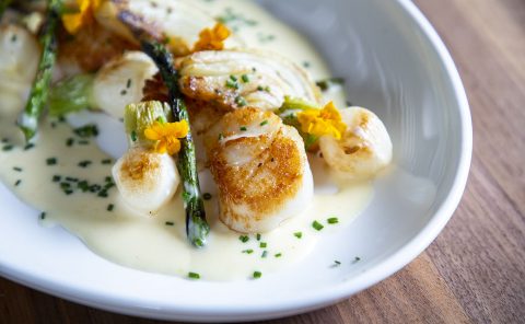 Gourmet seafood dish with scallops, asparagus, and creamy sauce at La Quinta Resort & Club.