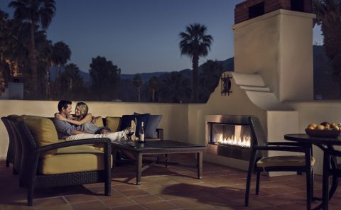 Relaxing couple enjoying evening on outdoor patio with fireplace at La Quinta Resort & Club.