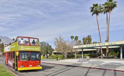 Vintage double-decker bus near Palm Springs City Hall in sunny weather.