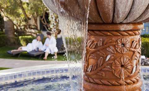 Elegant fountain at La Quinta Resort & Club with relaxing spa guests nearby.