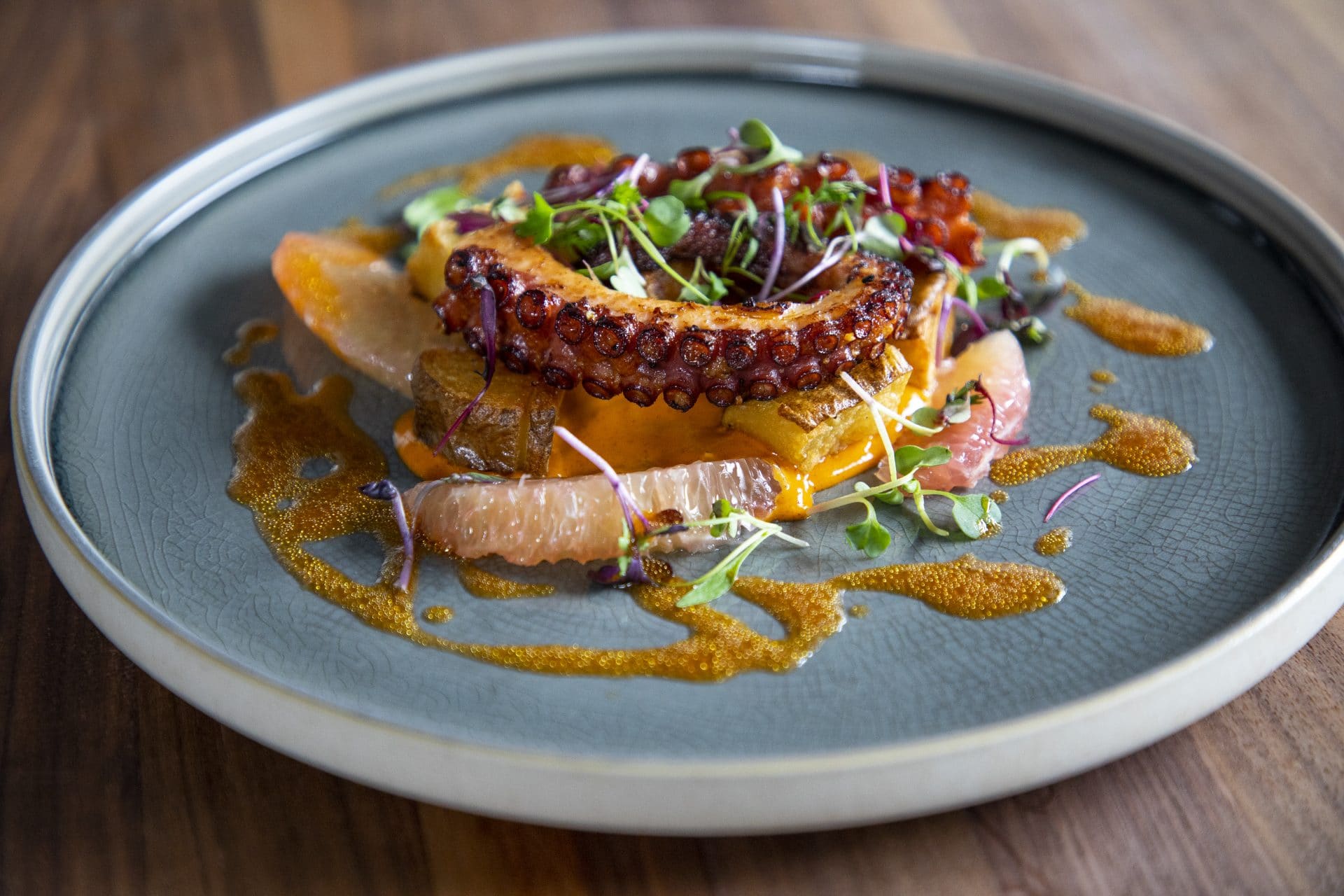 Gourmet octopus dish with fresh microgreens, sauce, and vibrant presentation at La Quinta Resort.