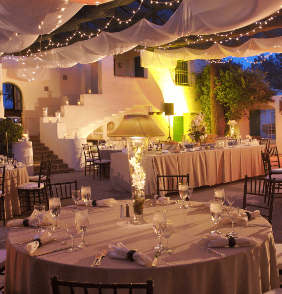 Outdoor wedding venue with string lights, elegant tables, and lush surroundings at La Quinta Resort.