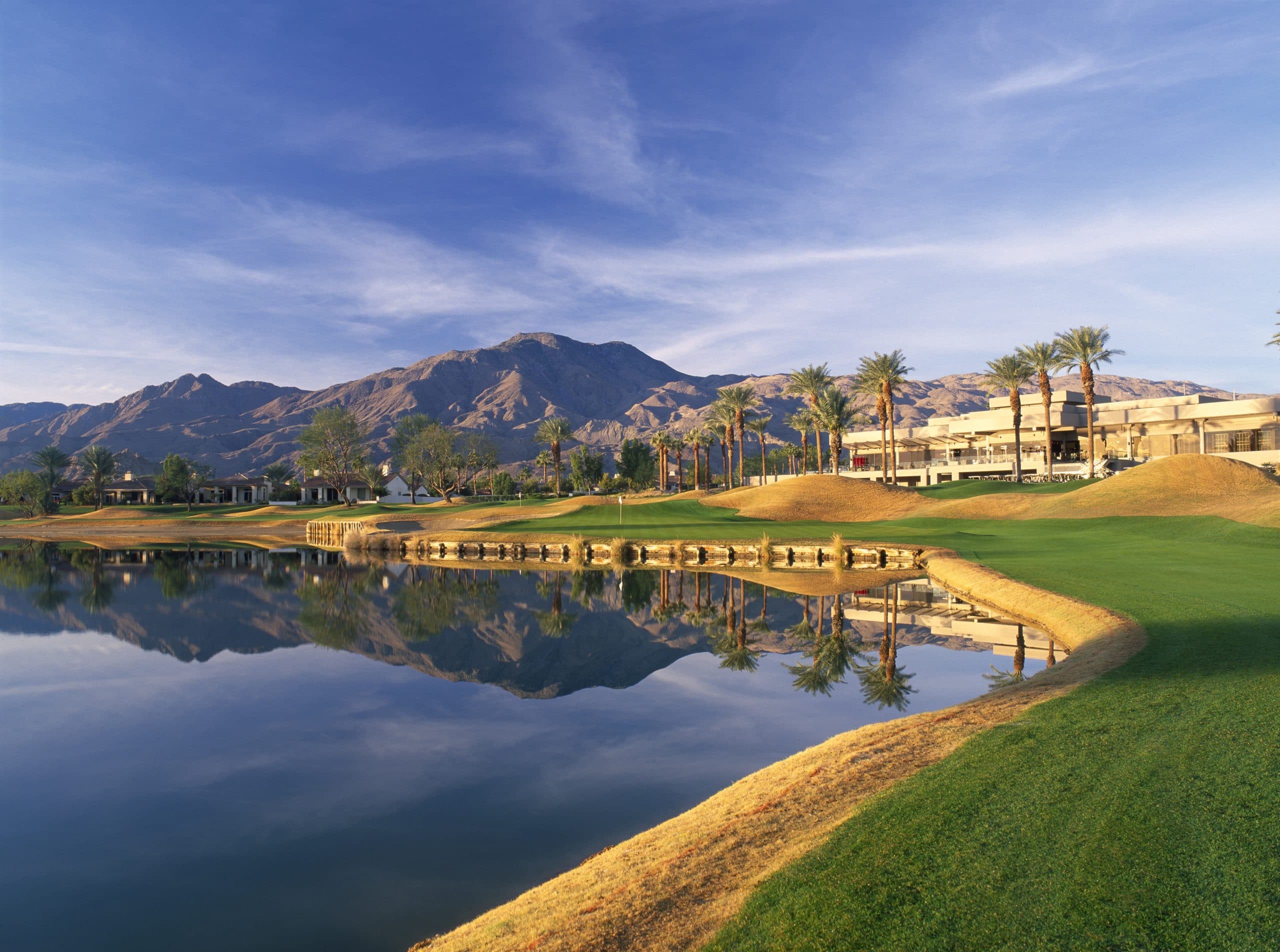 Golf course at La Quinta Resort & Club featuring lush greens, water hazards, and scenic mountain bac.