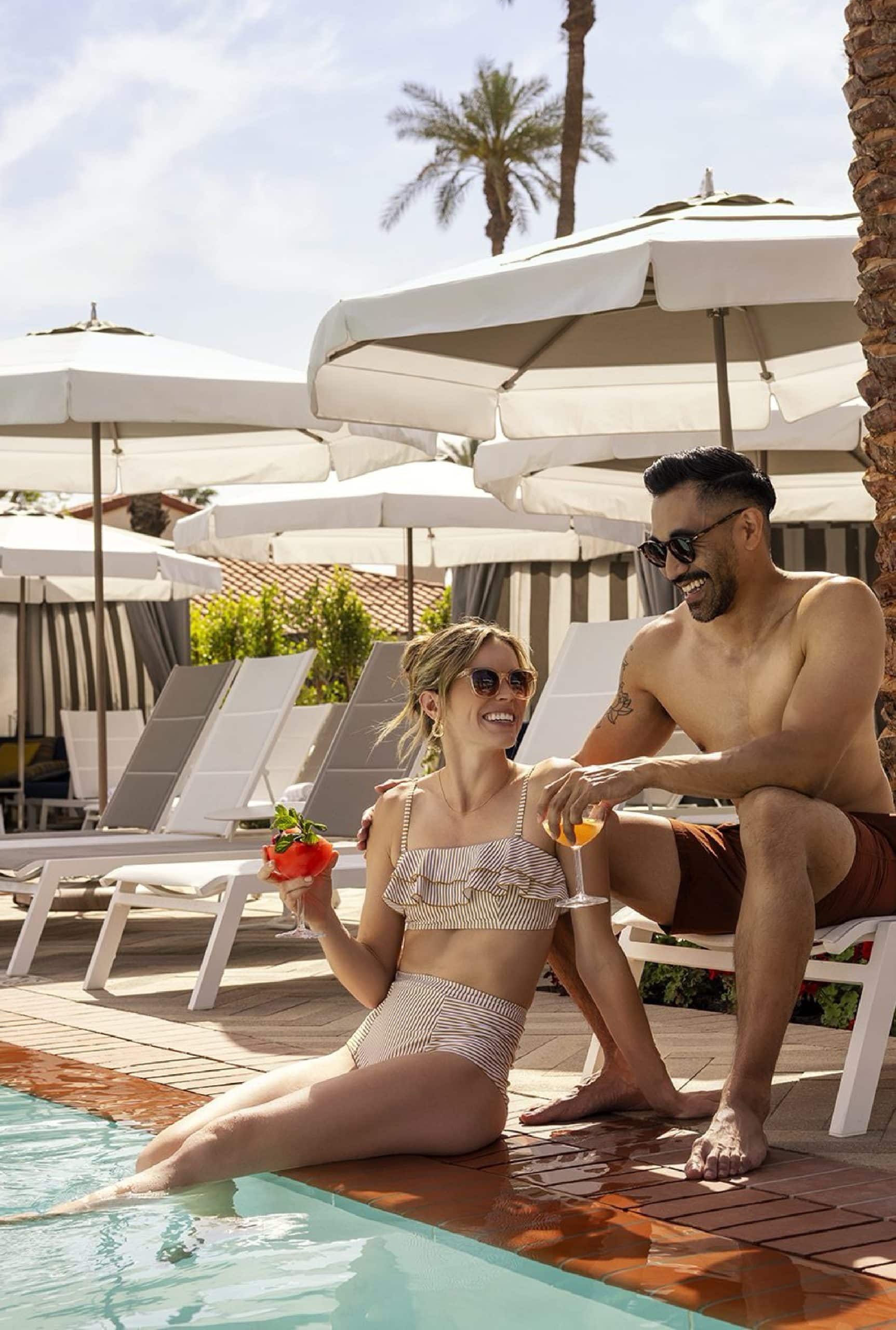 Happy couple enjoying drinks by the pool at La Quinta Resort & Club.