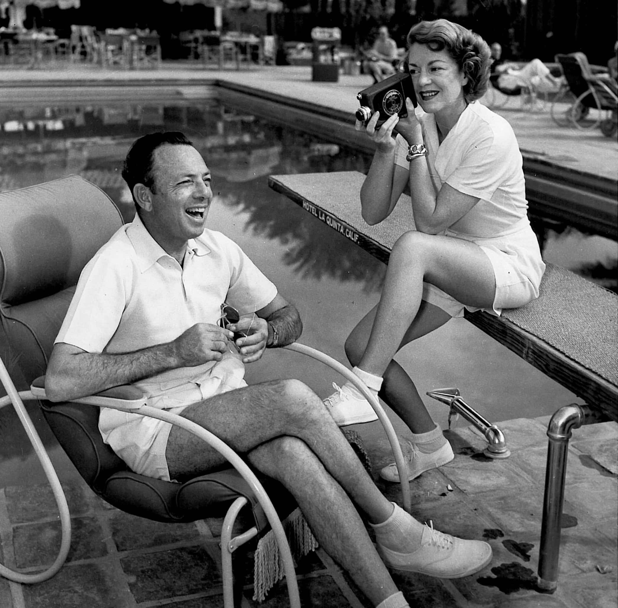 Vintage poolside scene with a man and woman enjoying leisure time.