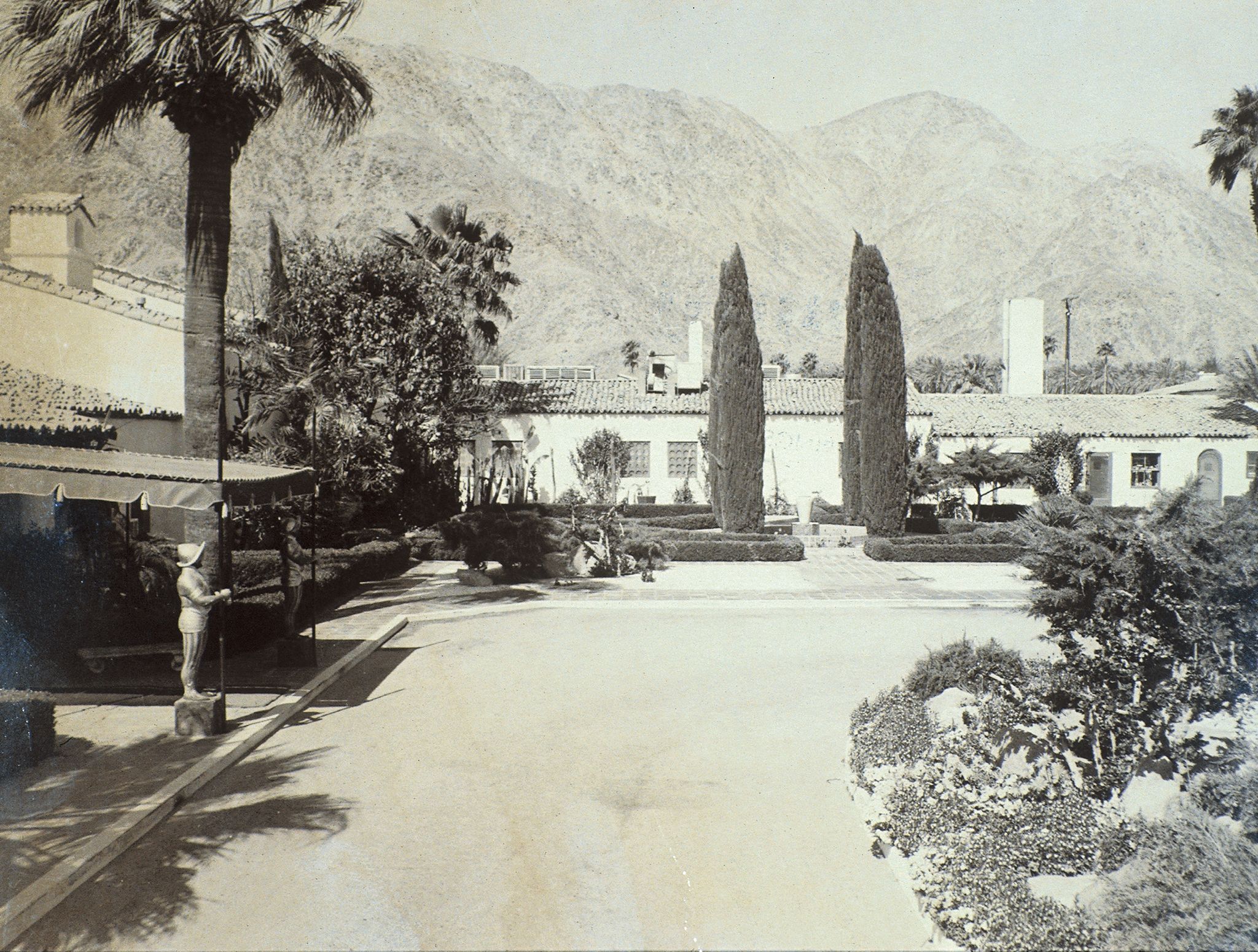 Historic entrance of La Quinta Resort & Club with palm trees and mountains in the background.