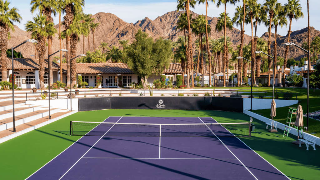 Tennis court at La Quinta Resort & Club with mountain views and palm trees.