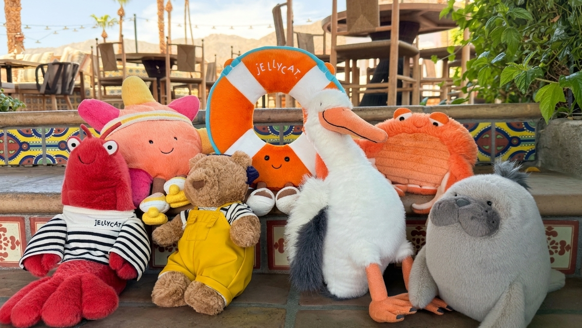 Colorful plush toys of Peppa Pig, a stork, crab, and other characters at La Quinta Resort poolside.