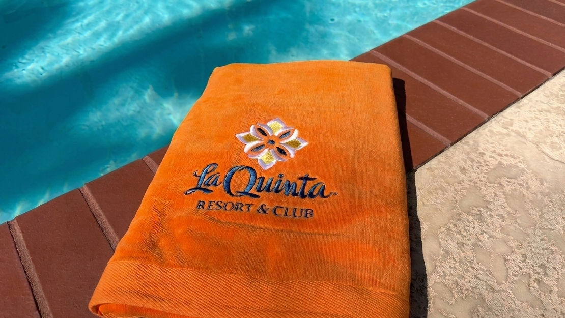 Poolside towel with La Quinta Resort & Club logo.