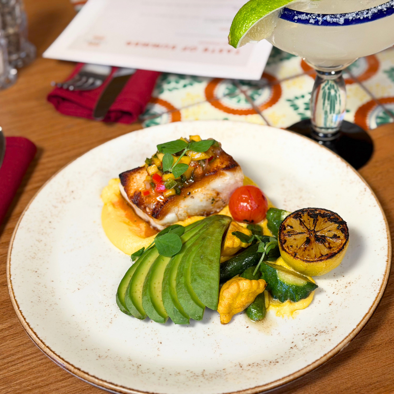 Delicious fish dish with avocado, grilled lemon, and vegetables at La Quinta Resort.