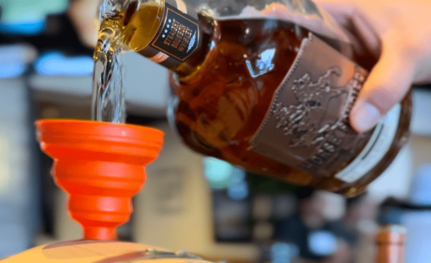 Person pouring whiskey into a glass at La Quinta Resort & Club.