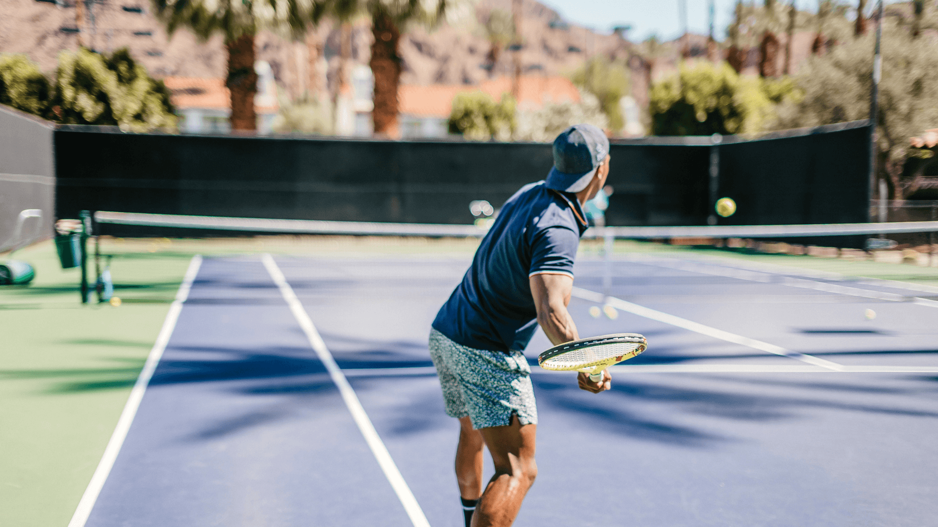 Tennis player hitting ball on outdoor court at La Quinta Resort & Club.