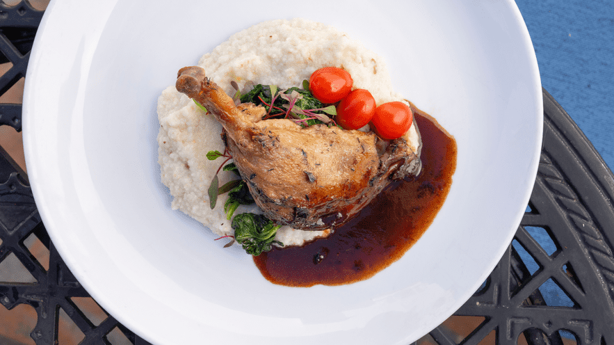 Gourmet dish with chicken, mashed potatoes, cherry tomatoes, and sauce at La Quinta Resort.