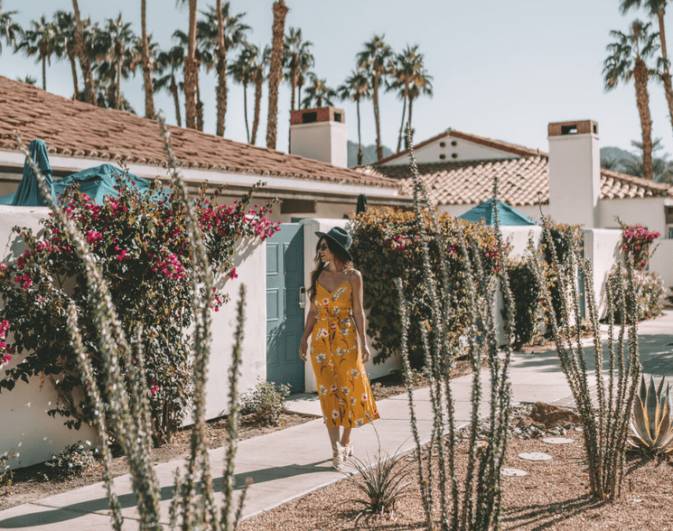 Woman in yellow dress walking through desert garden at La Quinta Resort.