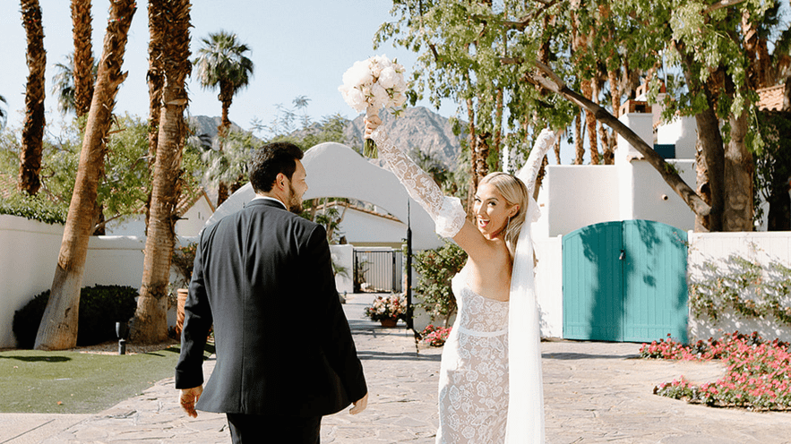 Bride and groom at La Quinta Resort & Club with palm trees and mountains.