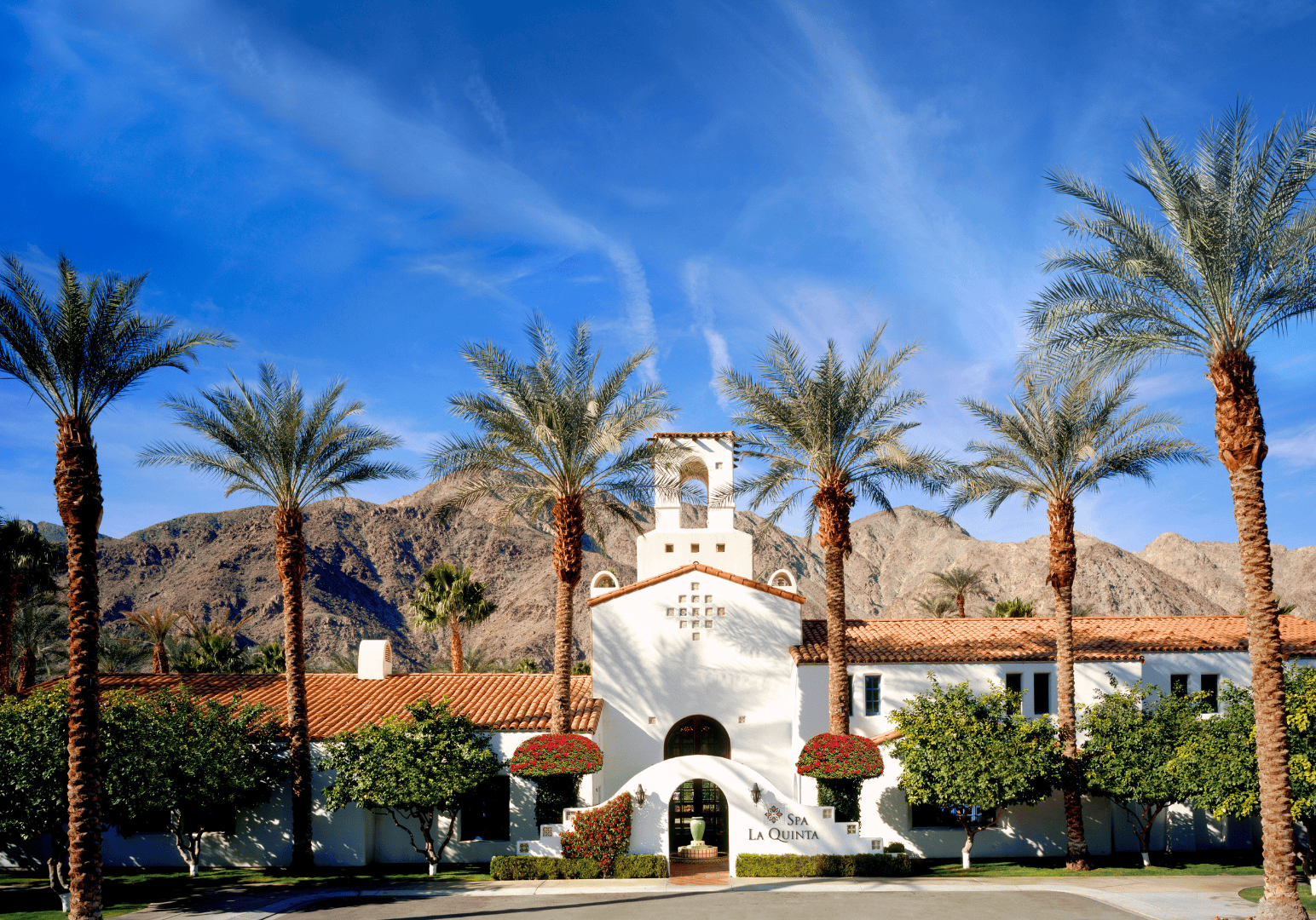 Historic La Quinta Resort with palm trees and mountains in the background.