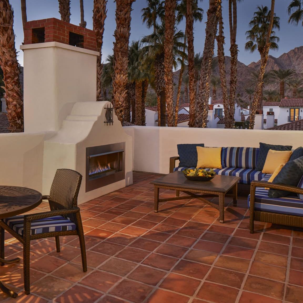 Outdoor meeting area with comfortable seating, fireplace, and scenic desert backdrop.