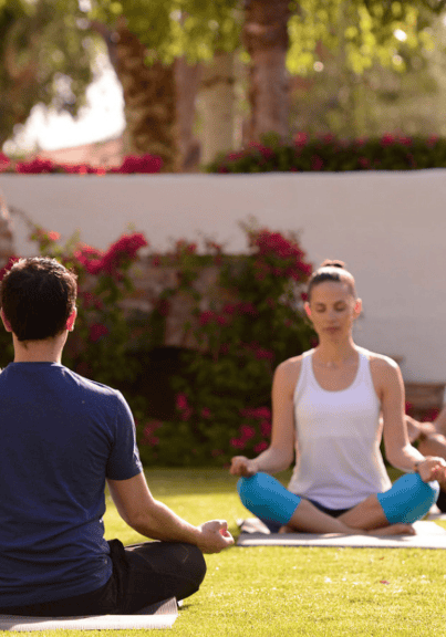 Group of people practicing yoga outdoors at La Quinta Resort & Club.