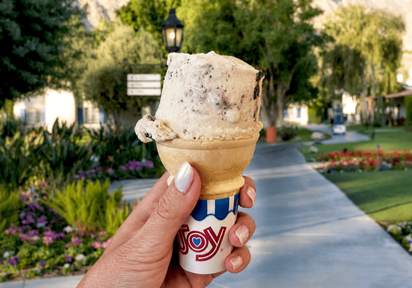 Hand holding ice cream cone outdoors during summer at La Quinta Resort & Club.