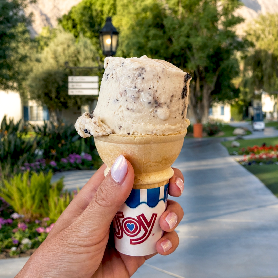 Hand holding ice cream cone outdoors during summer at La Quinta Resort & Club.