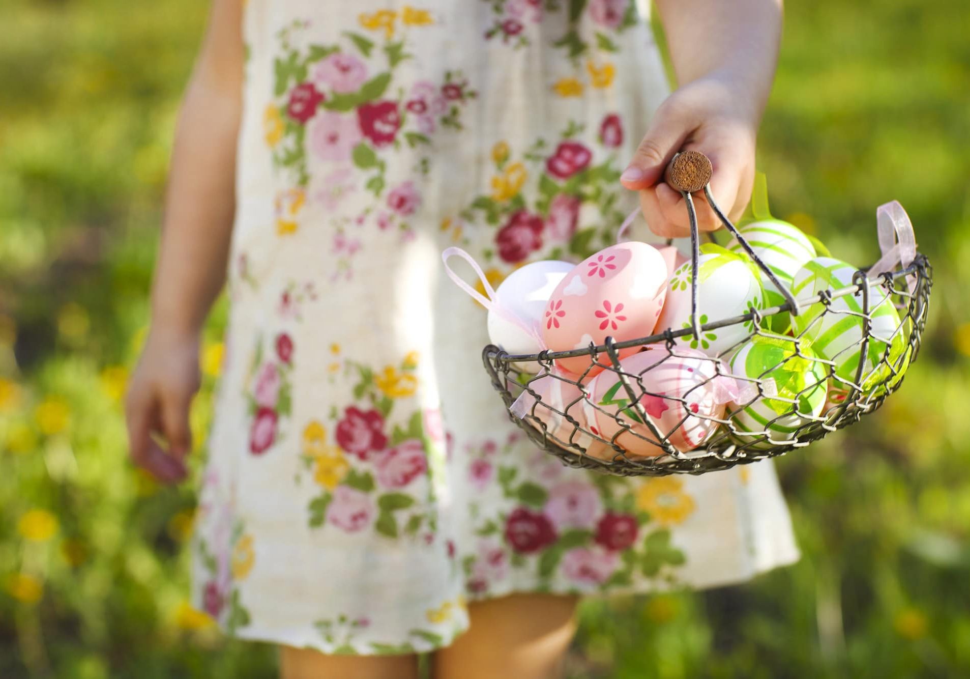 Child holding a basket of colorful Easter eggs outdoors at La Quinta Resort.