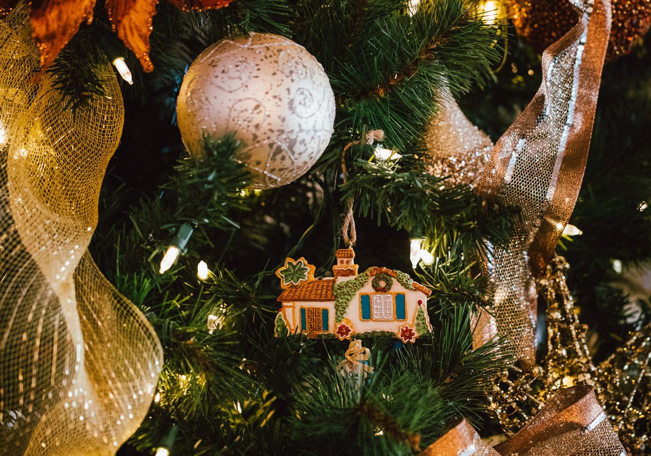 Decorated Christmas tree with ornaments, ribbons, and lights.