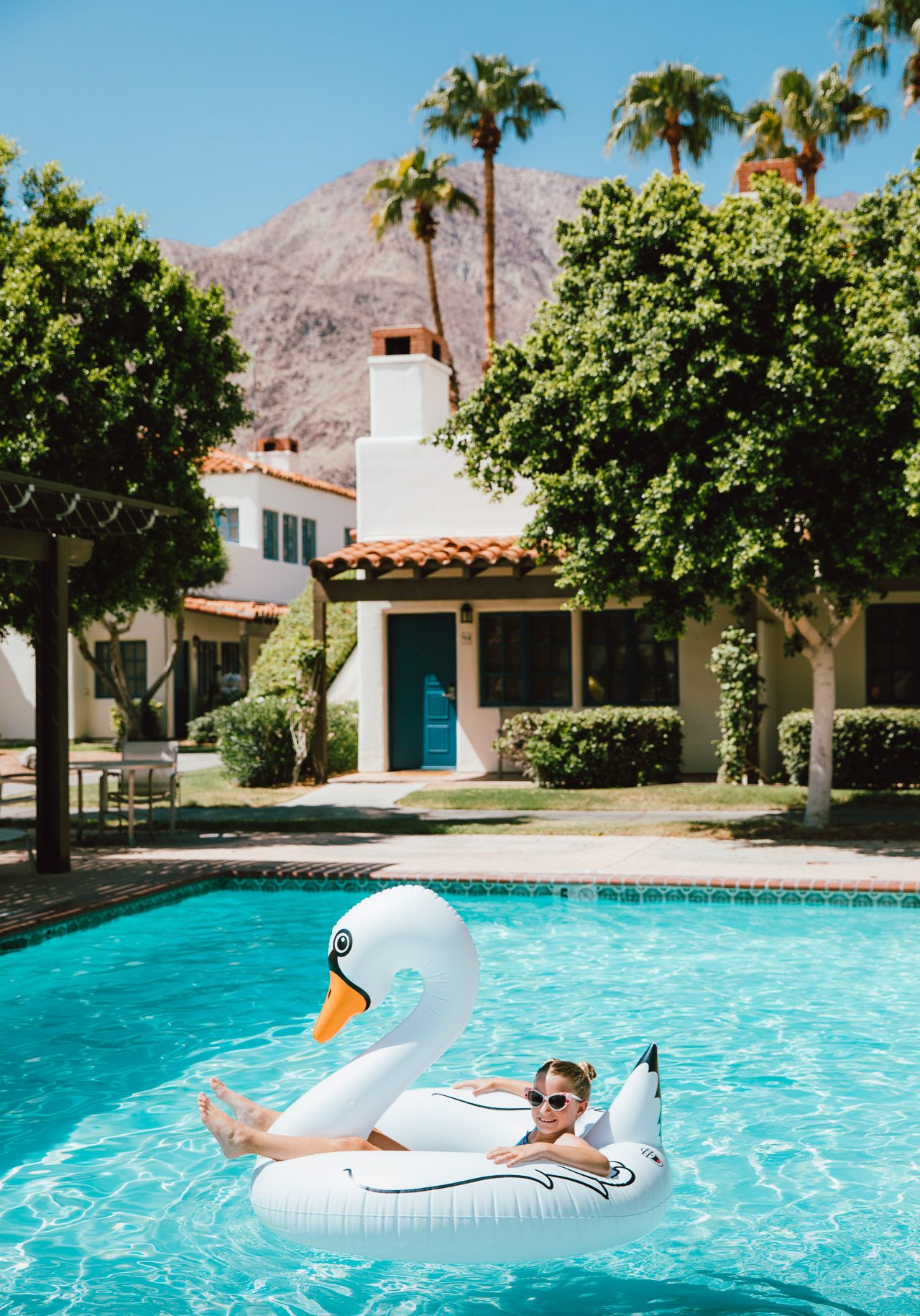 Child relaxing on a swan-shaped float in the pool at La Quinta Resort.