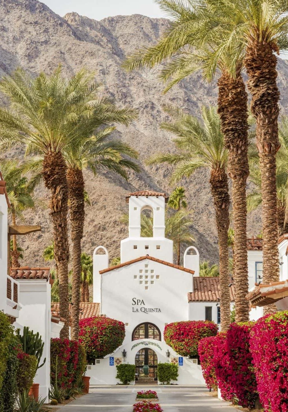 Entrance to La Quinta Resort & Club with palm trees and mountain backdrop.
